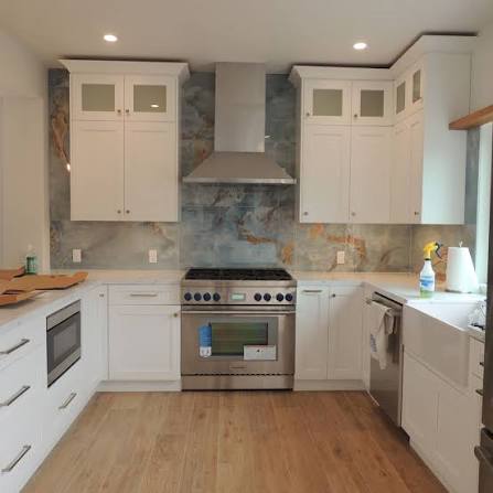 Stainless steel range hood above a pro-style range in a white kitchen