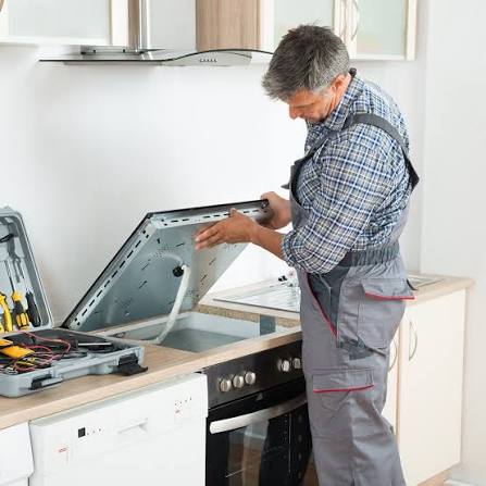 Local technician repairing a cooktop with a full tool kit ready